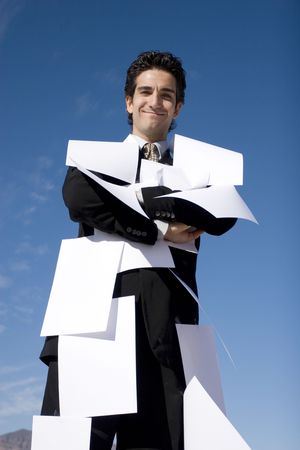 Businessman covered with white papersの写真素材