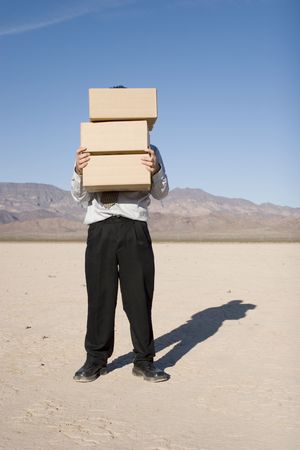 Businessman carrying heavy boxesの写真素材