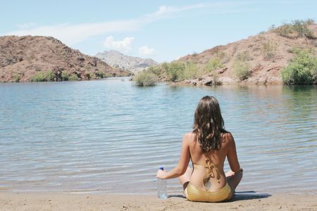 Woman sitting by the beachの写真素材