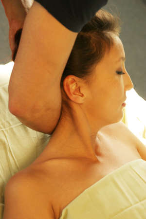 Massage therapist giving neck massageの写真素材