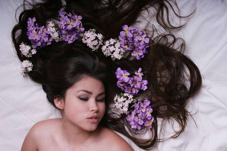 Sexy young woman with flowers on her hairの写真素材