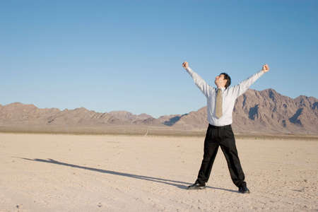 Happy businessman in the desertの写真素材