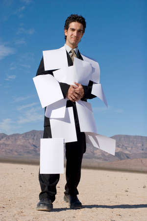 Businessman covered with white papersの写真素材