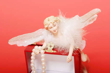 Christmas angel with a pearl on gift boxの写真素材