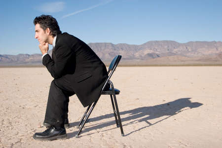 Businessman sitting alone in the empty desertの写真素材