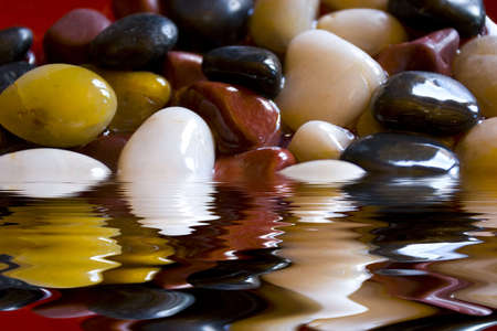 Various color pebbles in waterの写真素材