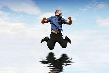 Happy businessman jumping in the airの写真素材