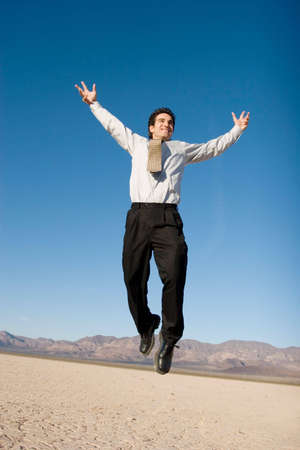 Happy businessman jumping in the airの写真素材