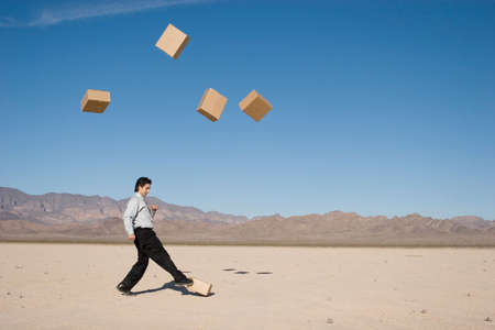 Businessman kicking boxes in the airの写真素材