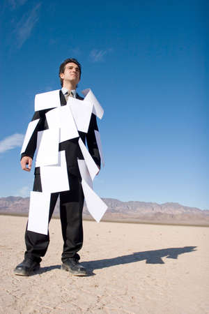 Businessman covered with white papers