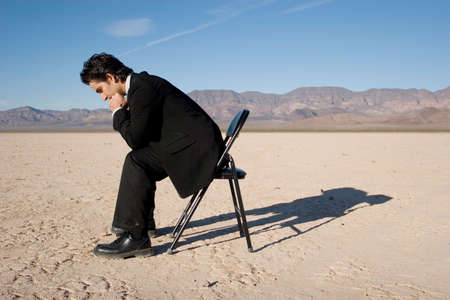 Businessman sitting alone in the empty desertの写真素材