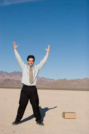 Businessman reaching up with his handsの写真素材