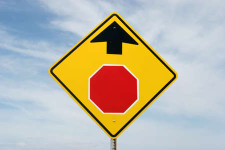 Stop ahead sign against blue cloudy skyの写真素材