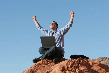 Happy businessman working on his laptopの写真素材