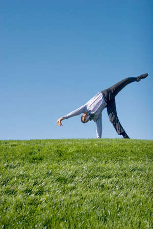 Happy businessman doing summersault on grassの写真素材