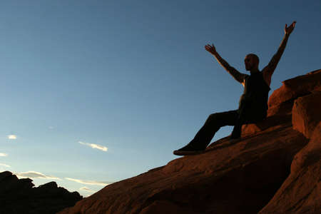 Silhouette of a man sitting on mountain top
