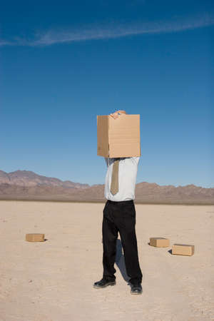 Businessman getting into a cardboard boxの写真素材