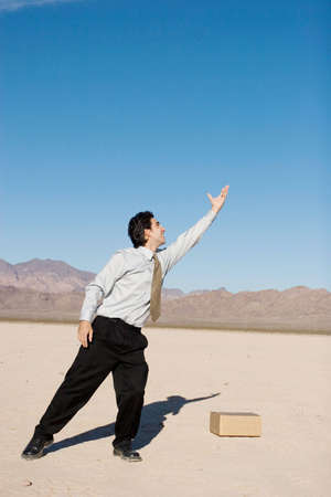 Businessman reaching up with his handsの写真素材