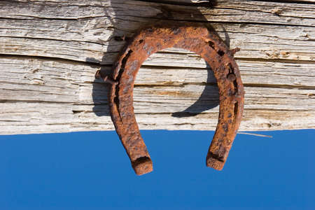 Horse shoe on wood against blue skyの写真素材