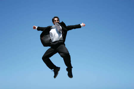 Ecstatic businessman jumping in the airの写真素材