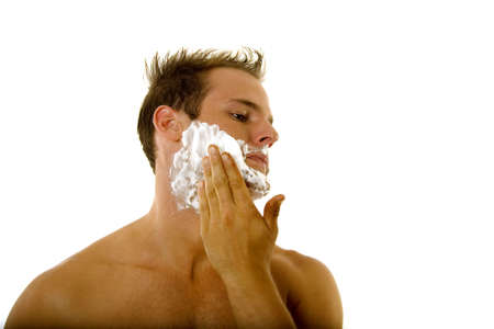 Young male putting shaving cream on his face