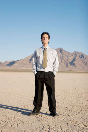 Young businessman standing in the desertの写真素材
