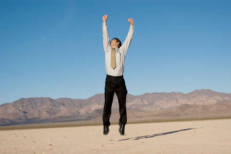 Happy businessman jumping in the airの写真素材