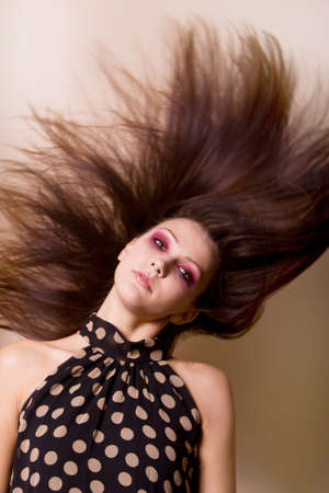 Beautiful fashionable young woman flipping her hairの写真素材