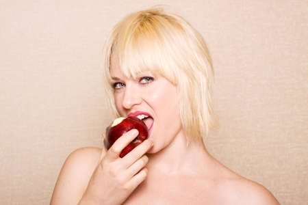 Woman eating a red appleの写真素材