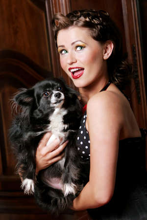 Pinup girl holding her pet dog