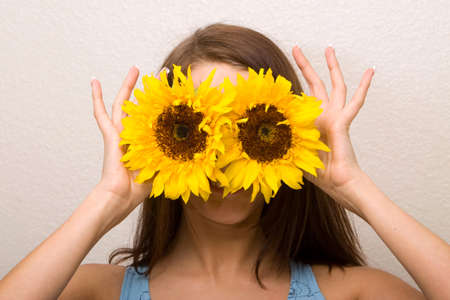 Beautiful young woman holding sunflowersの写真素材