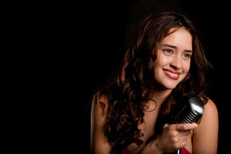 Beautiful singer singing with a retro microphoneの写真素材