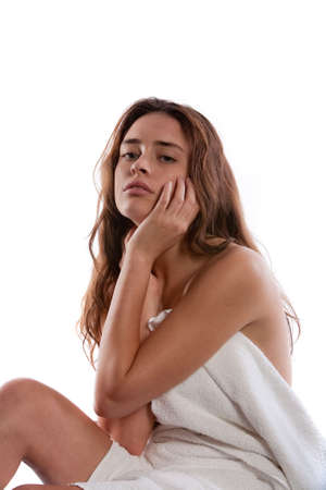 Beautiful young woman sitting on massage tableの写真素材