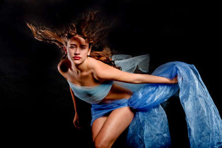 Beautiful sexy young woman in silk fabricの写真素材