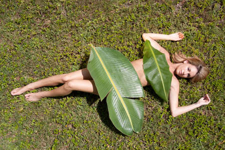Sexy woman covered in banana leavesの写真素材