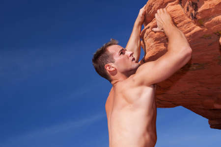 Athletic rock climber on red rocks