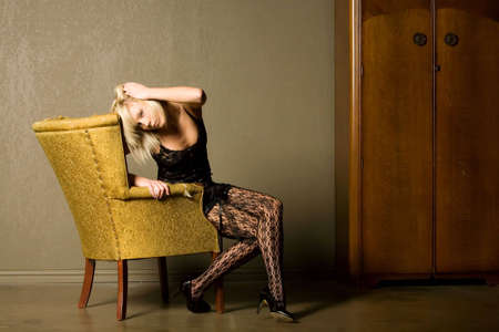 Gorgeous short hair blonde girl on an old chairの写真素材