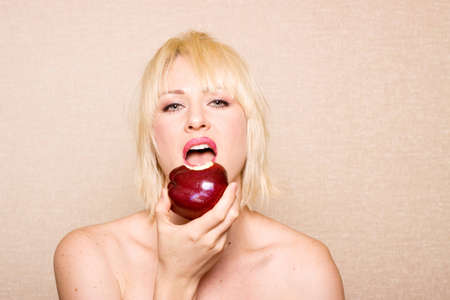 Woman eating a red appleの写真素材