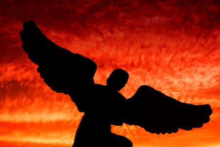 An angel silhouette during dramatic sunsetの写真素材