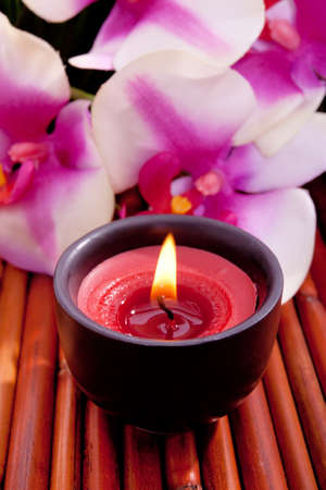 Spa candle and colorful orchid flower for aromatherapy meditationの写真素材