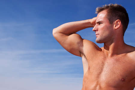 Handsome body builder on blue skyの写真素材
