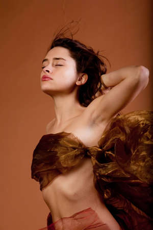 Beautiful sexy young woman in silk fabricの写真素材