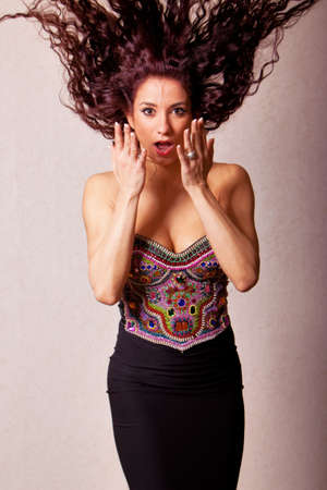 Gorgeous young ethnic woman in beautiful dress making facial expression