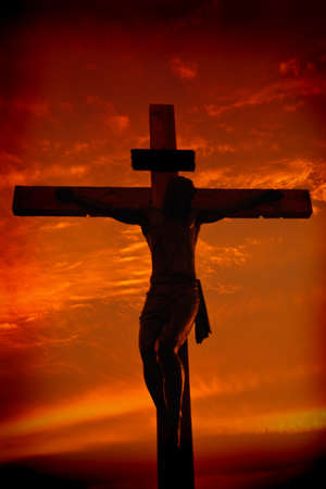 Crucifixion of Jesus Christ silhouette during sunset against dramatic skyの写真素材