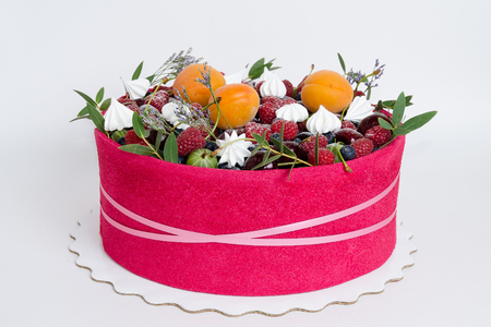 a beautiful fruit cake with a pink biscuit around itの写真素材