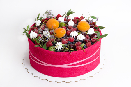 a beautiful fruit cake with a pink biscuit around itの写真素材
