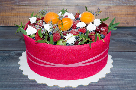 a beautiful fruit cake with a pink biscuit around itの写真素材