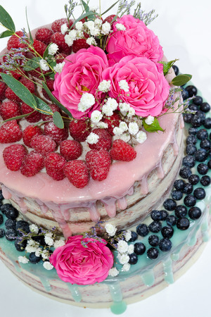 wedding color drip cake with roses, blueberries and  raspberriesの写真素材