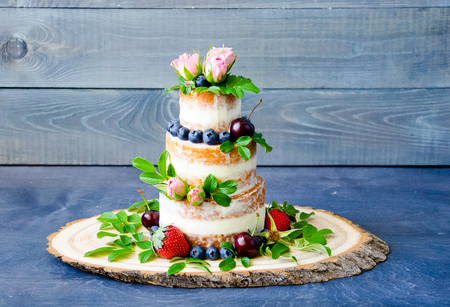Naked wedding cake decorated with berries and flowersの写真素材