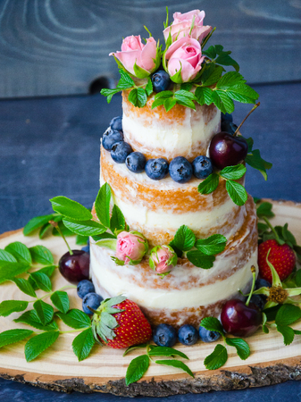 Naked wedding cake decorated with berries and flowersの写真素材